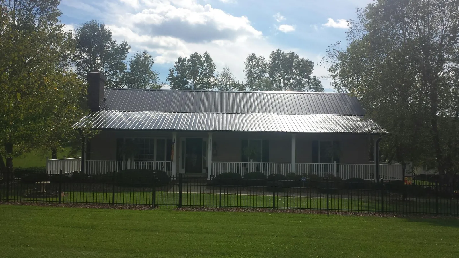 Gray metal roof on a brick ranch with a full width front porch — Gutter Guard Installation work by our crew in Bearsville