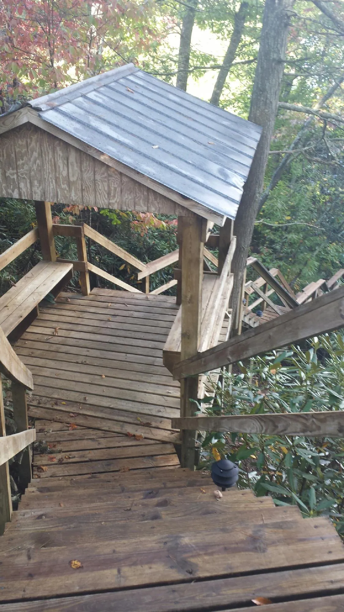 Metal roofed shelter over wooden steps on a wooded walkway — Skylight Repair & Installation work by our crew in Bearsville